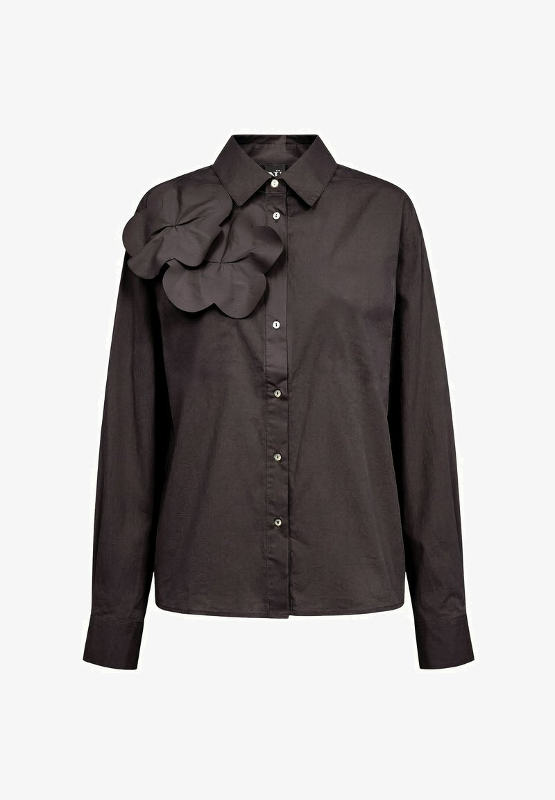 Chemise noire à manches longues boutonnée avec col et grand volant décoratif sur l'épaule gauche.