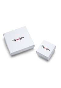 Weiße Geschenkboxen, eine große und eine kleine, mit einem schwarzen und roten "lululandjane"-Logo. Glatte Oberfläche, quadratische Form, minimales Design.