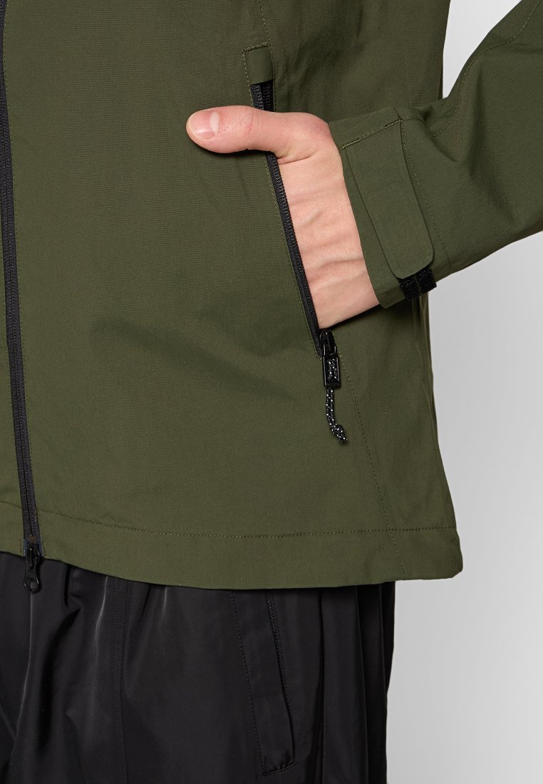 Olivgrüne Jacke mit glatter Textur, ausgestattet mit einer Reißverschlusstasche, verstellbarem Saum und schwarzen Akzenten für zusätzliche Details.