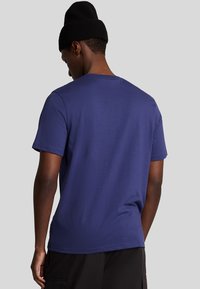 Maglietta a maniche corte blu navy con collo a giro, realizzata in tessuto morbido, caratterizzata da un design semplice e priva di motivi o loghi visibili.