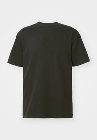 Svart t-shirt i bomull med rund hals. Har en ton-i-ton tryckt logotyp och designelement på framsidan. Korta ärmar.