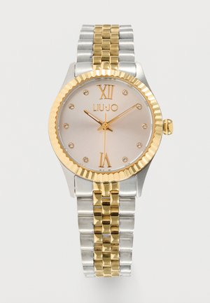 Orologio rotondo in argento con ghiera dorata, cinturino a maglie oro e argento, numeri romani XII e VI, indici orari in cristallo e nome del marchio "LIU•JO" sul quadrante.