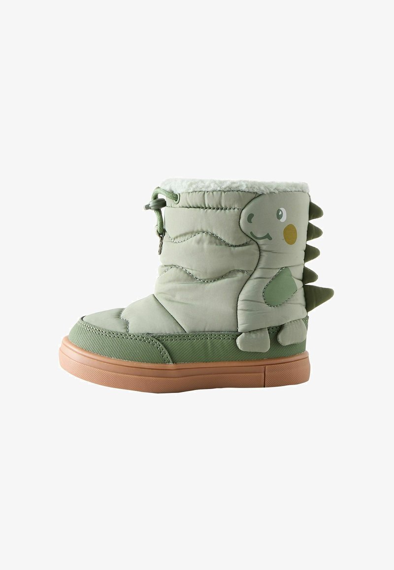 Botte en peluche verte avec un design matelassé, doublure en fourrure, semelle en caoutchouc marron et impression de dinosaure avec des pics à l'arrière. Fermeture éclair sur le côté.