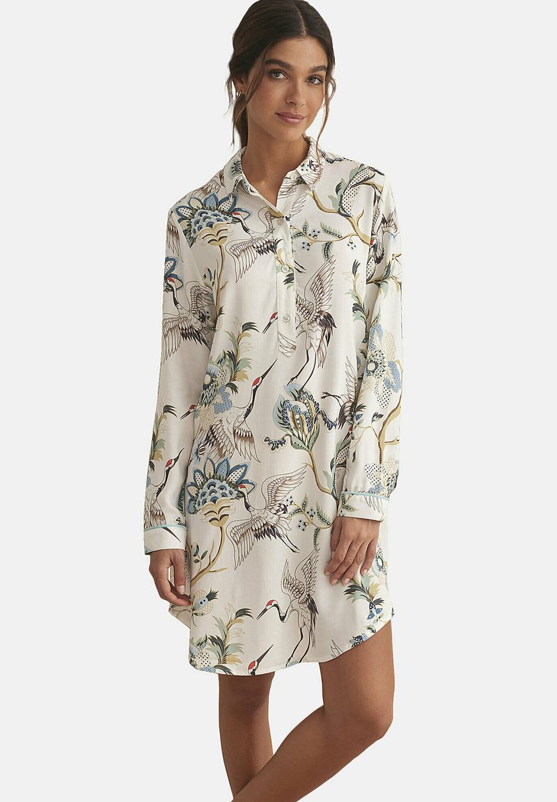 Robe chemise à manches longues en crème avec un imprimé détaillé de grues et de motifs floraux, dotée d'une fermeture à boutons sur le devant et d'un col classique.