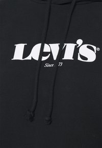 Sweat à capuche noir en coton avec capuche à cordon. Présente un grand logo blanc "LEVI'S" et le texte "Since 73" imprimés à l'avant.
