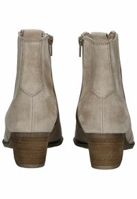 Botines de ante beige con un tacón bajo en bloque, que cuentan con cremalleras laterales y sutilezas de costura en la parte trasera y los lados.