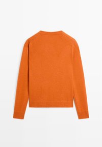 Orange knitted sweater with a round neck, long sleeves, ribbed hem, and a soft texture. Features a raglan sleeve design.