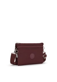 Borsa a tracolla bordeaux realizzata in nylon con texture liscia, scomparto con zip, tracolla regolabile e dettaglio del logo sul davanti.