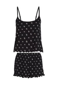 Conjunto de pijama negro que incluye una camiseta sin mangas con dobladillo en forma de ondas y pantalones cortos con cintura elástica, ambos con un patrón repetido de caras de dibujos animados en blanco.
