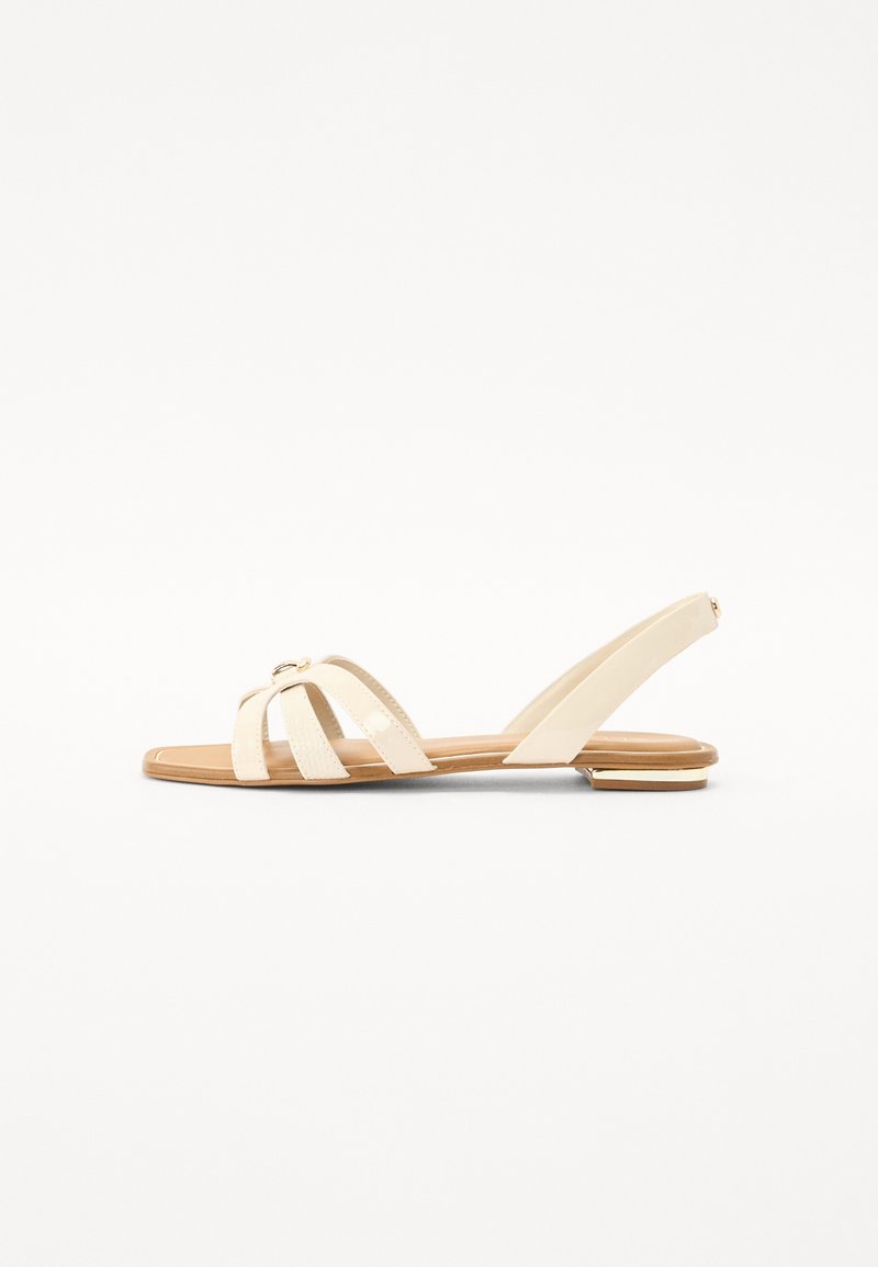 Sandale plate beige avec trois brides sur l’avant, une petite boucle en métal et une bride arrière avec un petit talon empilé.
