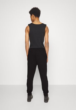 DUTSCHI - Tracksuit bottoms - black