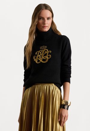 Maglione lavorato a maglia nero con collo alto e logo ricamato in oro, abbinato a una gonna plissettata metallica dorata. Presenta dettagli testurizzati.