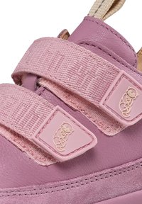 Rosa Sneaker mit einem Obermaterial aus Leder, strukturierten Klettverschlüssen und Bären-Logo-Details. Glatte und weiche Textur mit kontrastierendem Stich.