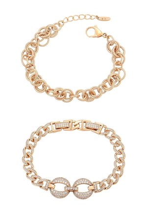 Dwie złote bransoletki łańcuchowe, jedna z teksturowanymi skręconymi ogniwami i zapięciem typu lobster, druga z ogniwami owalnymi i prostokątnymi ozdobionymi cyrkoniami.
