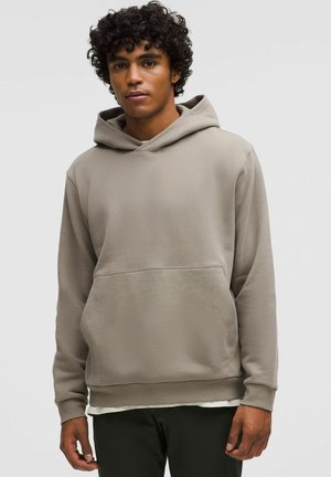 Pullover hoodie i dæmpet beige med en kængurulomme, justerbar snor i hætten og ribbede manchetter for en tæt pasform.