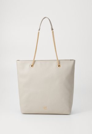 Beige tote bag with textured faux leather, minimalist design, gold chain straps, and subtle logo in the lower corner. Flat and structured shape.