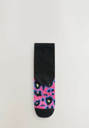 Juoda kulkšnine kojinė su ryškia rožine dalimi, puošta leopardų raštu juoda, mėlyna ir žalia spalvomis. Minkšta audinio tekstūra.