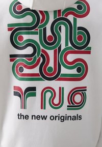 Hvit hettegenser med grafisk design bestående av grønne, røde og svarte bølgete linjer og prikker, samt teksten "de nye originalene."