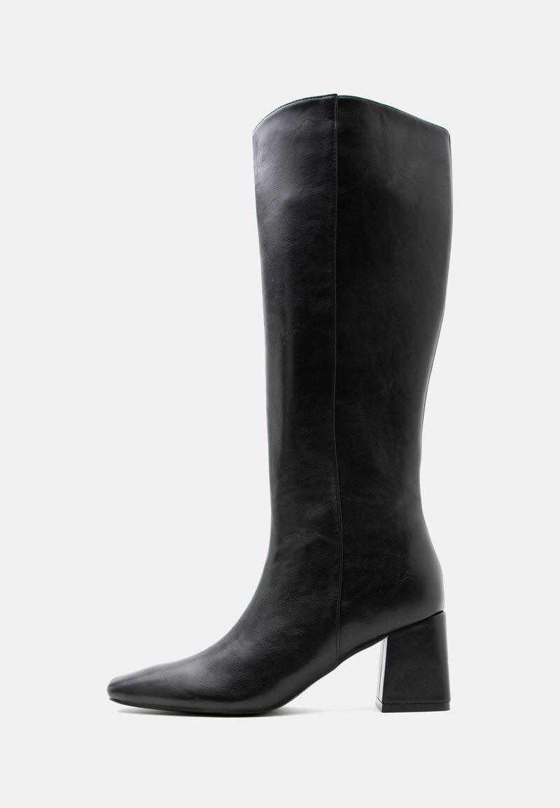 Botte haute en cuir noir avec un talon carré et un bout pointu, vue de côté sur un fond clair uni.