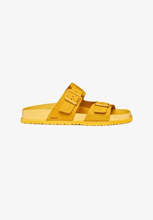 Sandale mule en daim jaune avec deux brides réglables à boucles et semelle texturée, vue latérale.