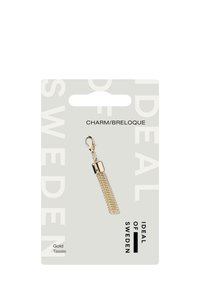 Goldener Charm mit strukturiertem Netzdesign, metallischem Gold-Finish und Befestigungspunkt. Auf einer hellgrauen Karte mit Markentext montiert.
