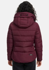 Bordeaux pufferjack met een capuchon, voorzien van een gequilt ontwerp, elastische hardware en een logo patch nabij de zoom. Textuur oppervlak met zichtbare naden.