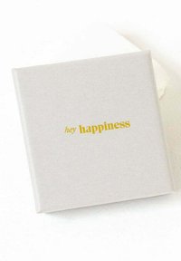 Caja cuadrada de color gris claro con una textura suave. El texto "hey happiness" está grabado en dorado, centrado en la parte frontal.