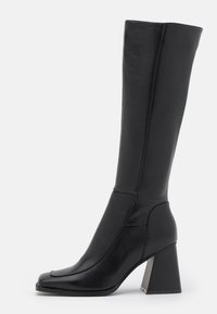 Bota de couro preta até ao joelho com bico quadrado, textura suave, design afunilado e salto bloco robusto. Apresenta detalhes de costura.