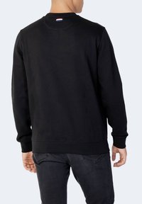 Černá mikina s kulatým výstřihem z bavlněné směsi, s žebrovanými manžetami a lemem a malou logo štítkem na zadní straně krku. Hladká textura.