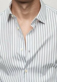 Witte overhemden met dunne verticale strepen in lichtblauw en groen. Knopsluiting aan de voorkant met twee zichtbare knoppen en een klein logo-embleem.