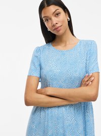 Niebieska sukienka z krótkimi rękawami, z okrągłym dekoltem i wzorem nieregularnych białych kropek. Gładka tekstura oraz luźny krój.