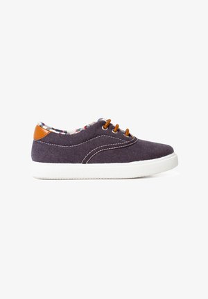 Canvas shoes in dark purple with white rubber sole, brown leather accents, and plaid lining. Features round toe and three brown laces.