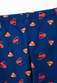 Blauwe katoenen pyjamashorts met een elastische tailleband, met een herhalend patroon van rode en gele superheldenlogo's.
