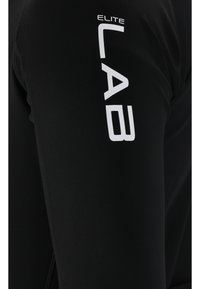 Schwarzes Sportbekleidungsstück mit enger Passform, an der Seite mit weißem "ELITE LAB" Branding. Das Material hat eine glatte, dehnbare Textur.