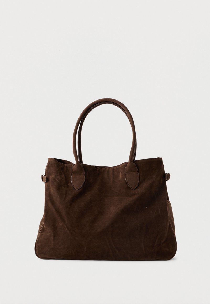 Hnědá suede tote taška s dvěma dlouhými ušima, oválnými prvky a prostorným designem. Měkká textura a minimalistický vzhled.
