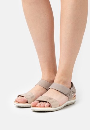 Sandali beige con apertura sulle punte, caratterizzati da una morbida finitura in suede, fasce larghe e una suola in gomma bianca testurizzata per aderenza e comfort.