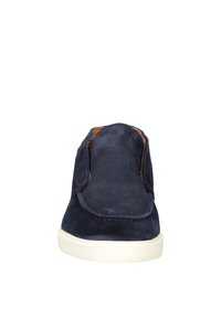 Navy suede instappers met een gladde textuur, voorzien van een witte rubberen zool en gestikte randen. Geen zichtbare hardware of patronen.