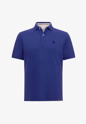 Sinine polo särgiga, klassikalise kraega, lühikeste varrukatega ja nuppliku. Rinnas on väike, tikitud logo.