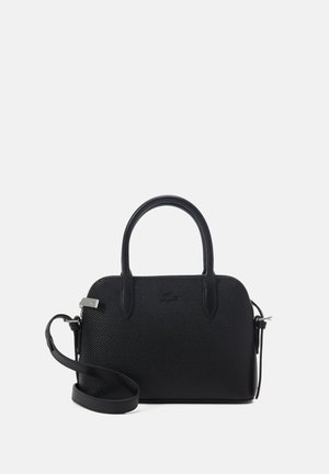 Bolso negro texturizado con dos asas y una correa ajustable para el hombro sobre un fondo liso y claro.