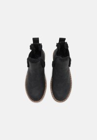 Svarta ankelboots med en slät yta, konstgjord pälsdetalj och kontrasterande sömmar. Har dragflikar f ör enkel påtagning.