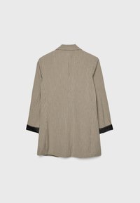 Brun rutigt blazer med en avslappnad passform, svarta satin detaljer på ärmarna, enkel bakslits, detaljerad textur och krage.