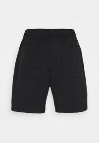 Shorts noirs en coton avec une taille élastique et deux poches plaquées à l'arrière, présentés sur un fond clair uni.
