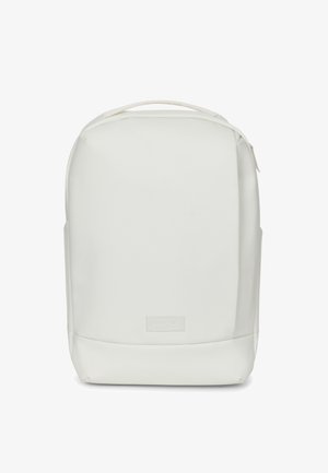 Weißer Rucksack mit glatter, matter Oberfläche, gerundetem oberen Teil, Frontreißverschluss und einem kleinen geprägten Logo am unteren Bereich.