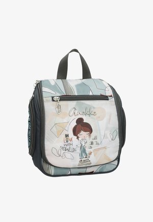 Piccolo zaino quadrato con tasche con cerniera, raffigurante una ragazza dei cartoni animati in piedi su dei libri e la frase "Innamorata della conoscenza."