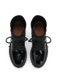 Botas tobillo sintéticas negras con acabado brillante, punta redonda y cordones. Parte superior texturizada y cuello acolchado, con detalles de herrajes plateados.