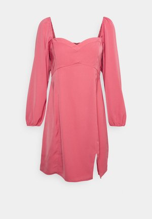 Vestido de cetim rosa com mangas bufantes longas, decote coração e uma fenda lateral. Textura suave e corpete justo com uma saia fluida.