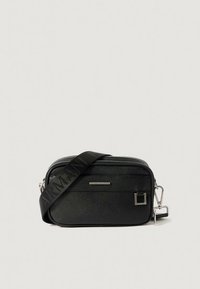 Crna torbica na rame od teksturiranog sintetičkog materijala, s patentnim zatvaračem, remenom s logotipom i detaljima u srebrnoj boji.