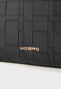Sac à main tissé noir en cuir, avec une texture lisse et un accent logo en ton doré. Le motif carrée crée une profondeur visuelle.