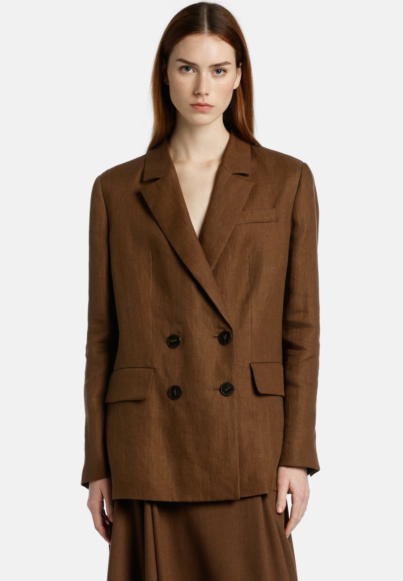 Blazer en lin marron à double boutonnage avec revers, deux poches avant et boutons noirs. Texture lisse et coupe ajustée.