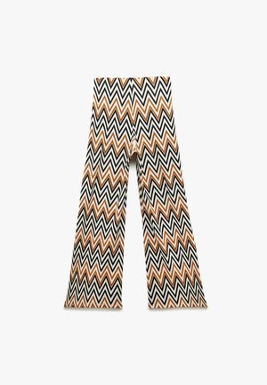 Pantaloni a gamba larga con motivo zigzag in bianco, nero e arancione, caratterizzati da una vita alta e un tessuto fluido, che offrono un design geometrico distintivo.